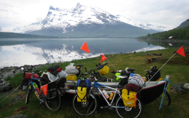 After pedaling all day, we found a beach on a fjord to camp. We stacked the bikes around the dory and set up the tents. Later, we cooked dinner and watched the clouds and sun create incredible colors and shapes all over the mountains. A very beautiful evening captured in on photograph. 