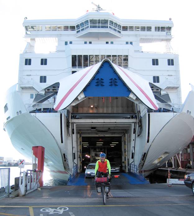 Cyclist escaping the open jaws of a ferry ship, Lofotan Island, Norway © 2012 Frosty Wooldridge